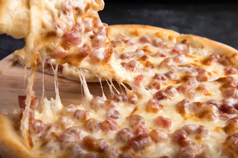 Close-up of a delicious pepperoni pizza slice with gooey mozzarella cheese