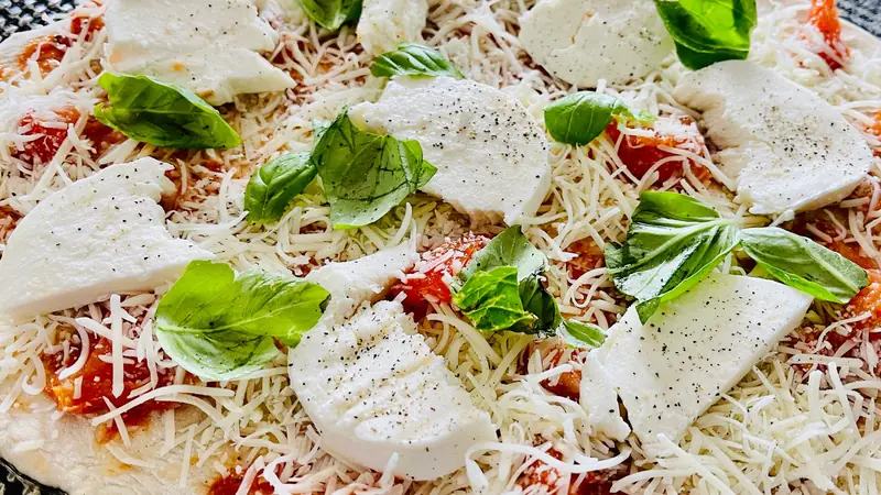 Close-up of a homemade Margherita pizza with cheese, mozzarella, tomato sauce, and fresh basil