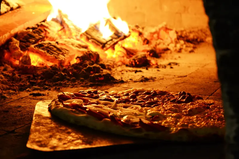 Mouthwatering pizza cooking in a traditional wood-fired oven, capturing the essence of Italian cuisine