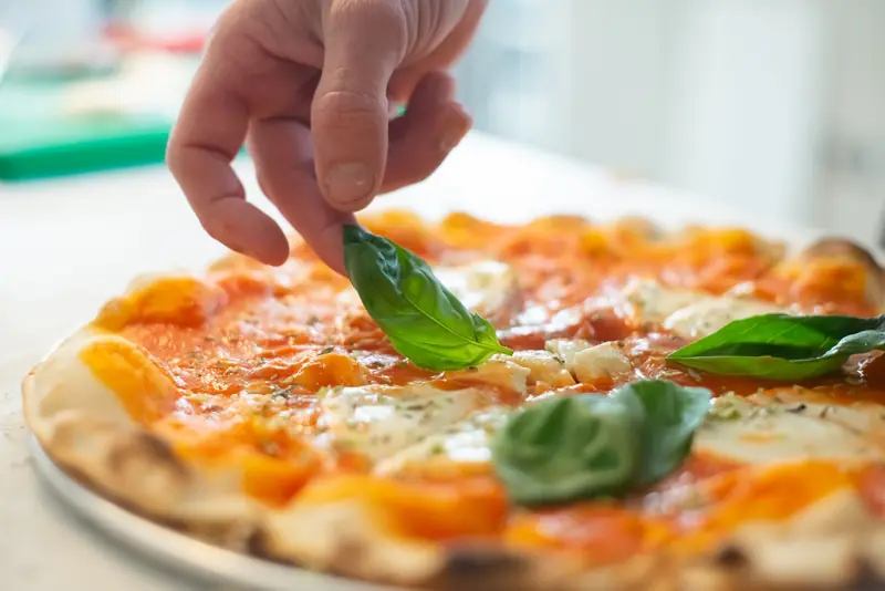 A close-up of a delicious, freshly baked pizza topped with basil leaves and melted cheese