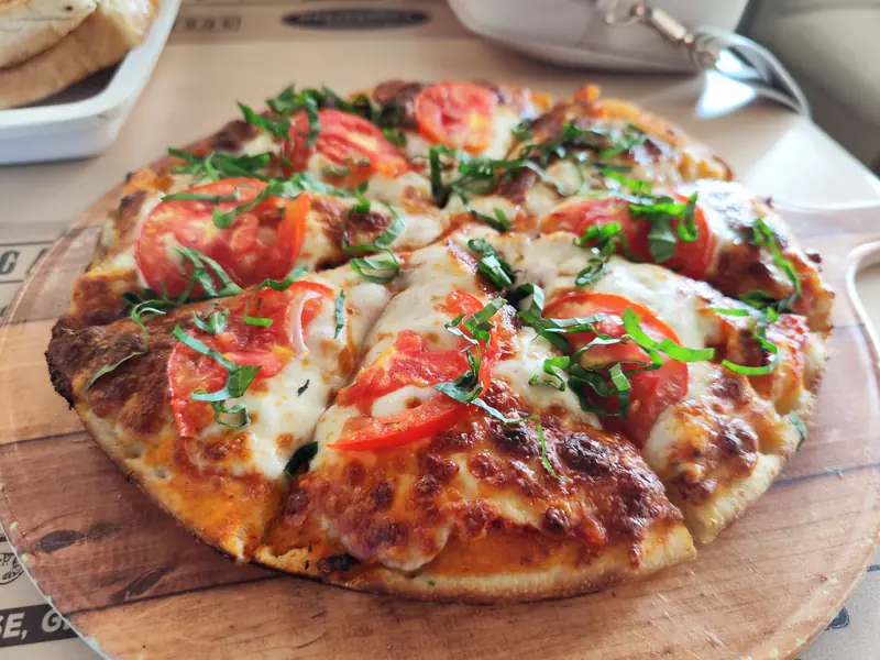 Close-up of a fresh Margherita pizza with tomatoes and basil. Perfect for Italian cuisine promotions