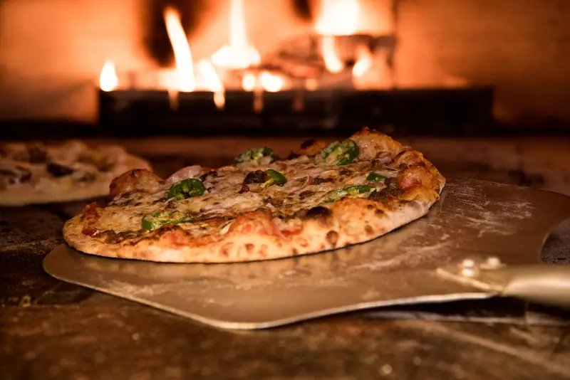 Appetizing gourmet pizza cooked in a wood-fired oven, showcasing artisanal toppings